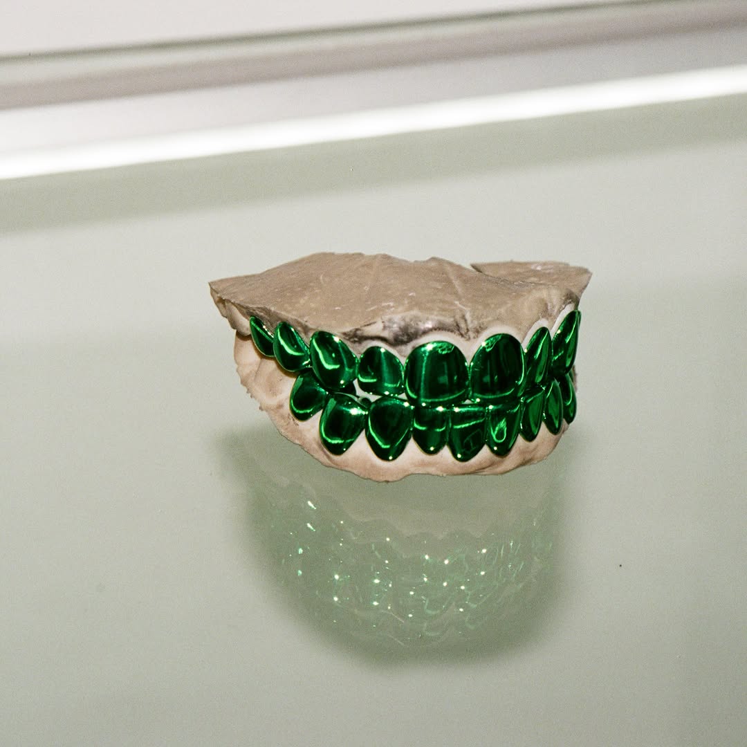 The green grillz on a glass shelf